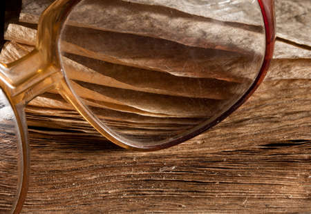 Antique glasses on old weathered book. Close-up viewの写真素材