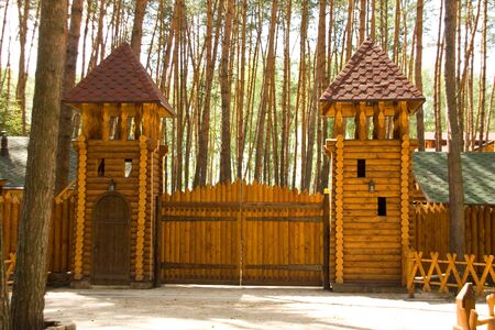 Big wood gates and two towers in forestの写真素材