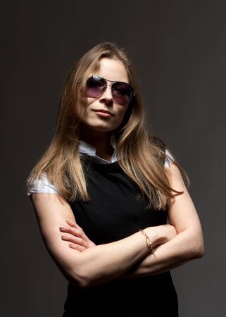 Portrait of beautiful woman in glasses with crossed armsの写真素材
