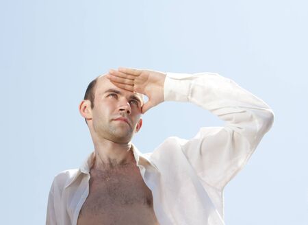 Serious man in white shirt looking afarの写真素材