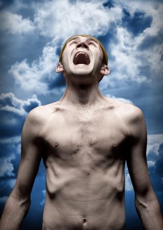 Portrait of despaired screaming man against dramatic skyの写真素材