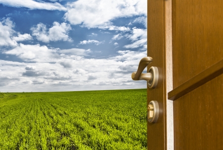 Freedom. Open door to green field and blue skyの写真素材