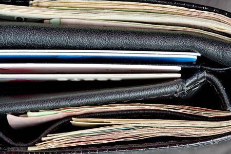 Close-up of black leather wallet with cards and moneyの写真素材