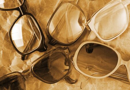 Many antique glasses on old weathered paper. Sepia tonedの写真素材