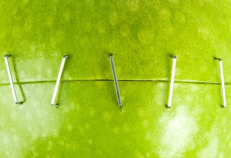 Two parts of green apple stapled together. Background or textureの写真素材