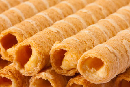 Close-up of striped wafer rolls filled with creamの写真素材