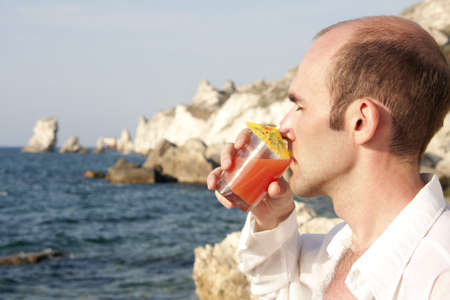 Man drinking cocktail on the beachの写真素材