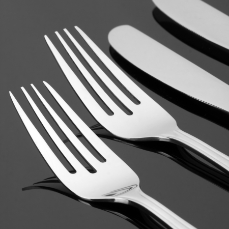 Close-up of forks and knives. In B/W