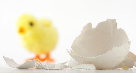 Eggshell cracks and newborn toy chicken behindの写真素材