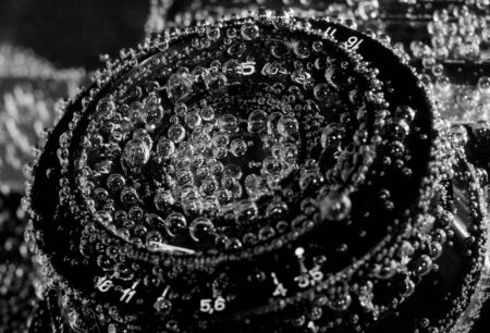 Close-up of old drowned camera lens under waterの写真素材