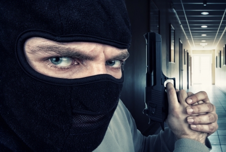 Close-up of serious armed criminal with gunの写真素材