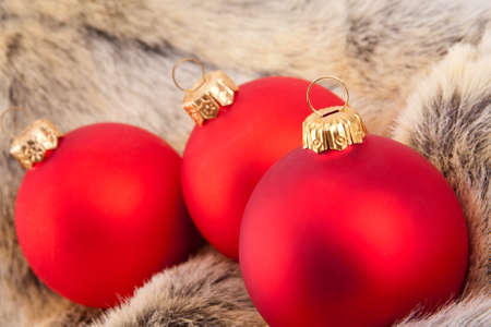 Three Christmas red baubles on animal furの写真素材