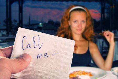 Call me... message on napkin in hand against pretty girlの写真素材