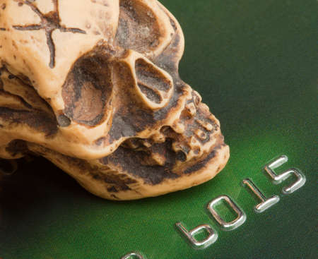 Bankruptcy concept. Human skull on credit cardの写真素材
