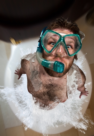 Bizarre man with swimming mask leaping out from toiletの写真素材