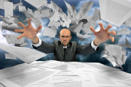Serious businessman manipulating papers against dramatic blue skyの写真素材