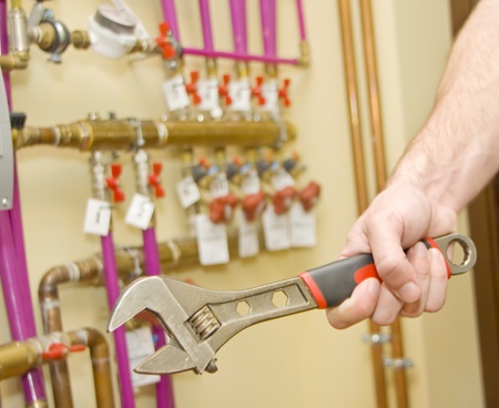 Servicing heating and water systems. Hand with adjustable spannerの写真素材
