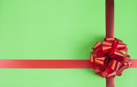 Red gift bow and ribbons on green paperの写真素材