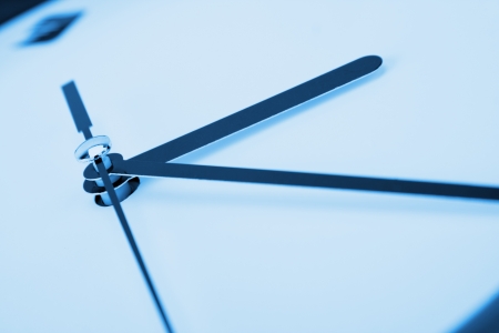 Close-up of clock hands. Toned in blue