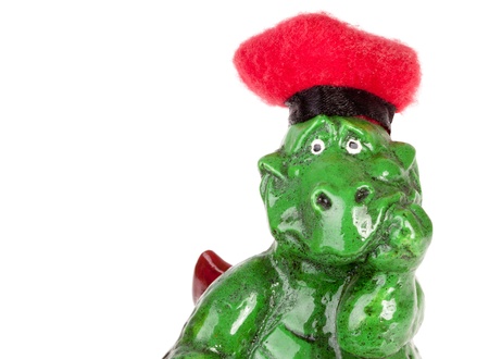 Statuette of funny dragon in red hat. Isolated on whiteの写真素材