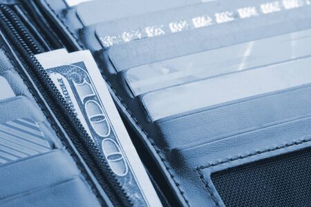 Black leather wallet with credit cards and money. Toned in blue