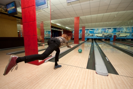 Funny beginner girl playing bowling. Wide angleの写真素材