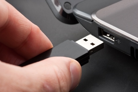 Plugging removable flash disk memory into laptop USB slotの写真素材