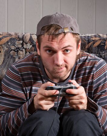 Surprised man with joystick playing video games at home
