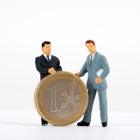 Miniature figurines of businessmen with one euro coinの写真素材