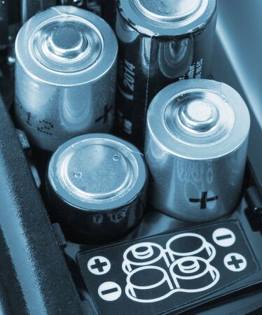 Loading batteries into a electronic device. Toned in blueの写真素材