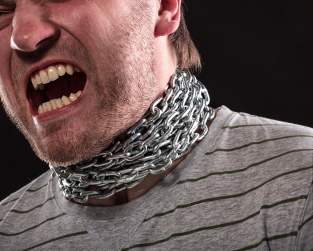 Screaming man with iron chain around neckの写真素材