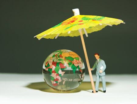 Security man holding umbrella under glass globeの写真素材
