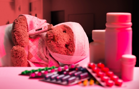 Ill teddy bear sleeping in hospital bedの写真素材