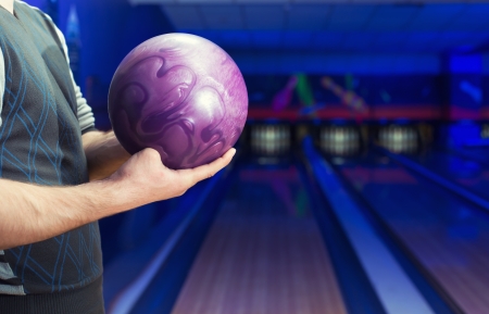 Man holding ball against bowling alleyの写真素材