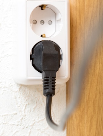Closeup of electrical plug in wall outlet