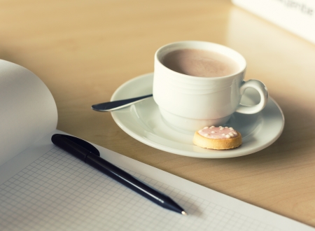 Cup of coffee and notepad with penの写真素材