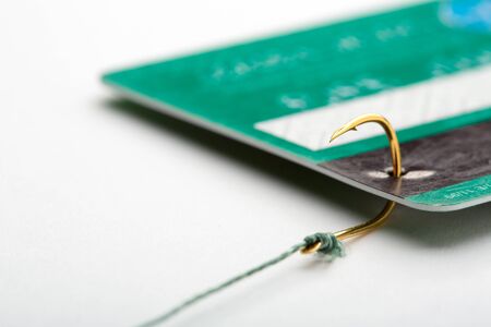 Closeup of a credit card caught on a fishing hookの写真素材