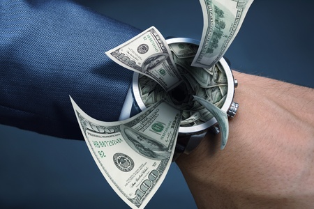 Watch on businessman hand sucking moneyの写真素材