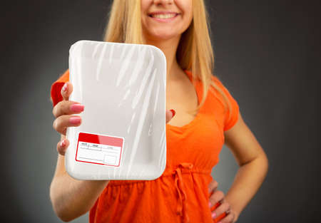 Young blondie woman holding empty food trayの写真素材