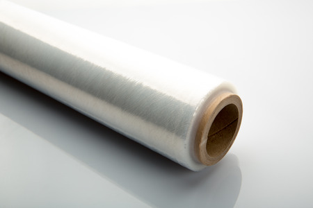 Roll of wrapping plastic stretch film on white の写真素材