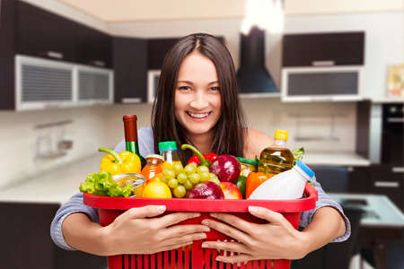 Young girl with a basket full of goodsの写真素材