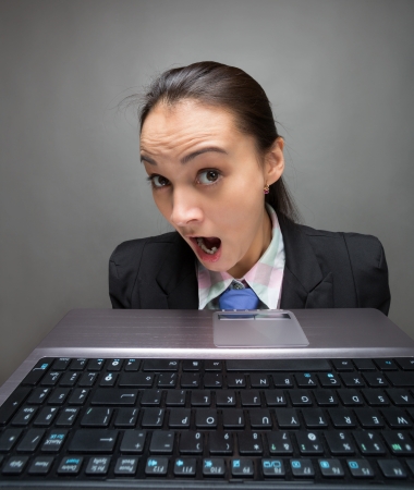 Young caucasian businesswoman hiding behind laptopの写真素材