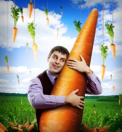 Huge carrot and businessman under blue skyの写真素材