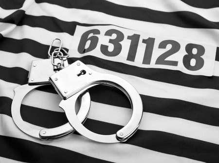 Striped dress for prisoners? handcuffs and numberの写真素材