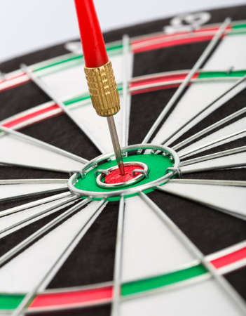 Closeup picture of dart board with dart on white background
