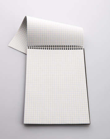 checkered paper notebook isolated on gray