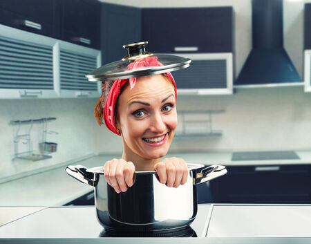 Smiling housewife inside sause panの写真素材