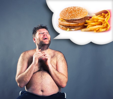 Fat funny man dreaming about  hamburger isolated on grayの写真素材