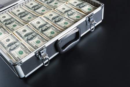 Case full of dollar isolated on gray の写真素材