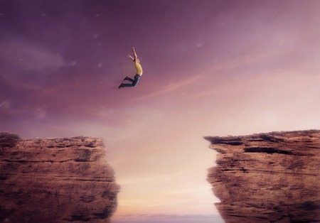 young man jumping off between a cliffs
